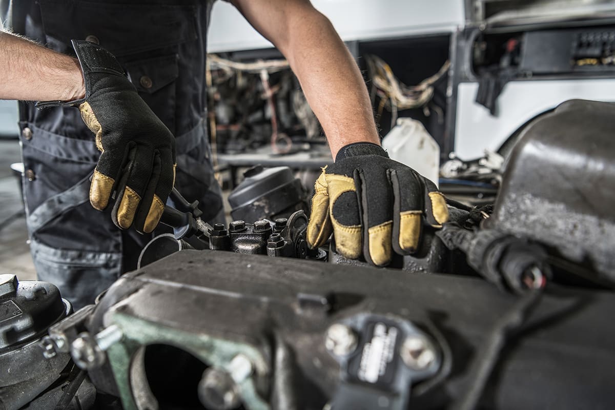 Professional Automotive Caucasian Mechanic Repair Semi Truck Diesel Engine Close Up.